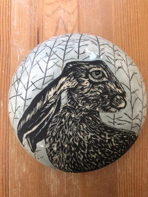 Round dish with a hare in reeds illustration