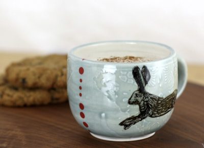 Mug with a running hare illustration, served with cookies