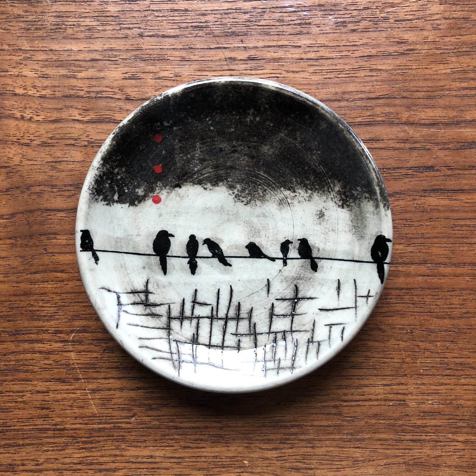 Plate with birds perched on a wire