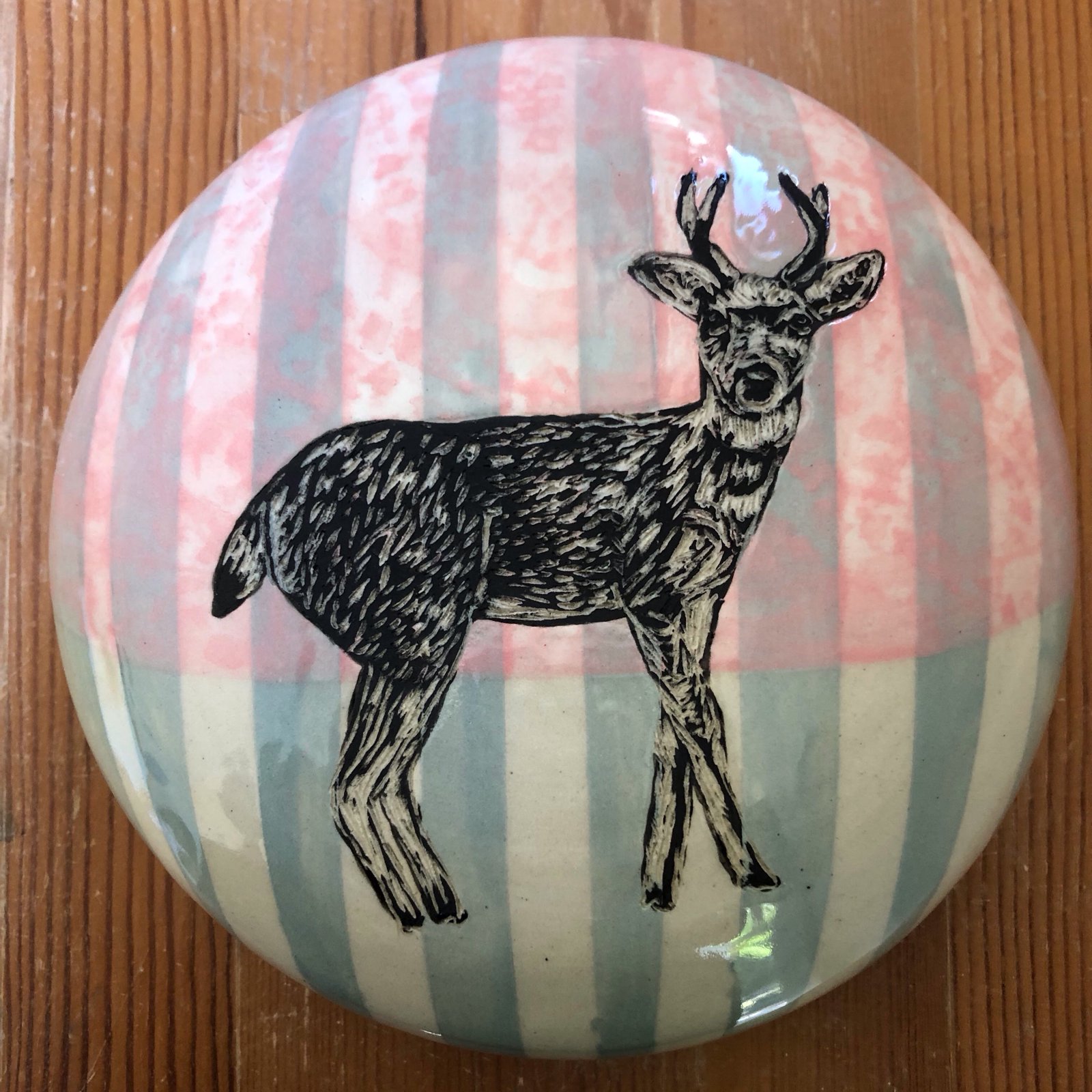 Round dish with a stag illustration on striped glaze
